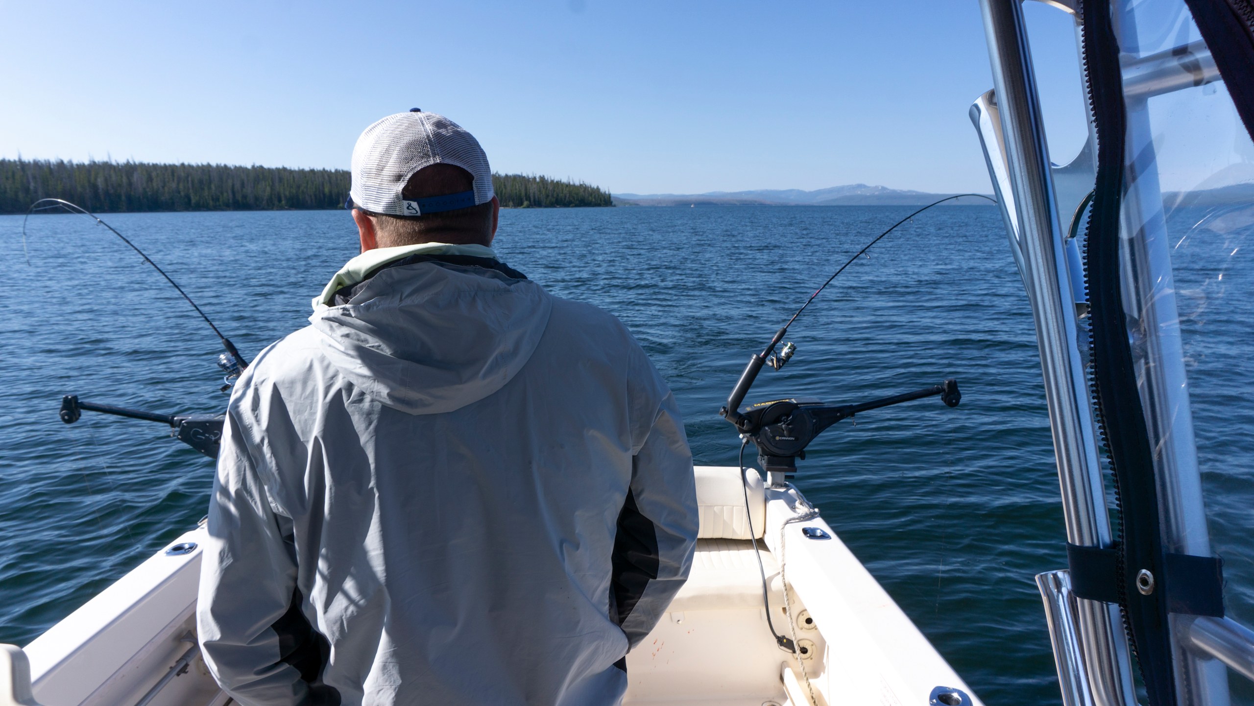 Back of a boat with a person watching fishing rods